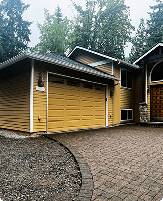 Yellow garage door with brick driveway